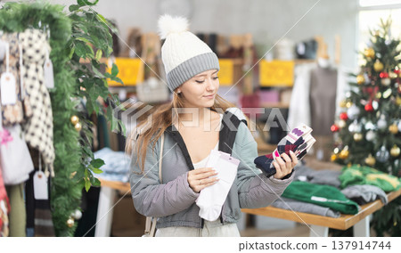 Young woman holding a set of socks in the store 137914744