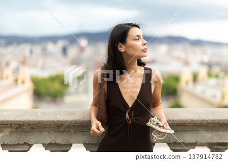Young woman standing on street with mobile in her hands 137914782