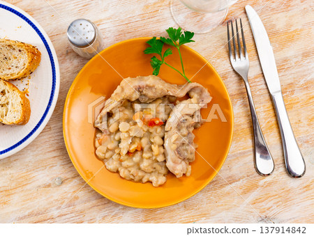 Fried rabbit on a plate with beans and parsley Fried rabbit on a plate with beans and parsley 137914842