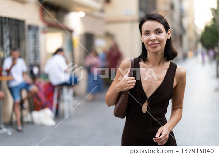 Woman walks along narrow street between buildings of 19th century 137915040