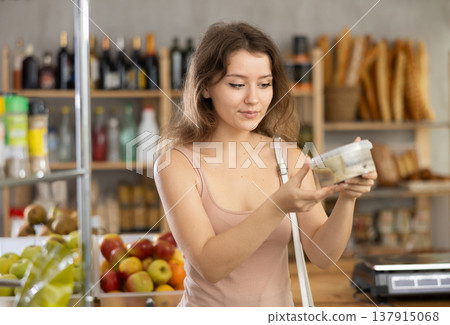 Young girl is scanning QR on cheese in grocery store Young girl is scanning QR on cheese in grocery store 137915068