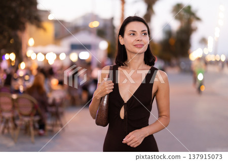 In evening, girl walks around old city district Barceloneta, pedestrian embankment In evening, girl walks around old city district Barceloneta, pedestrian embankment 137915073