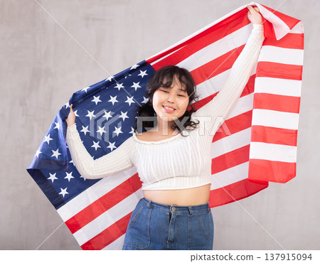 Smiling young girl holding USA flag 137915094