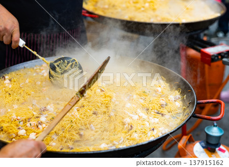 Preparation of Catalan seafood fideua in paellera on street festival Preparation of Catalan seafood fideua in paellera on street festival 137915162