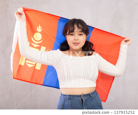 Displeased young girl holding flag of Mongolia Displeased young girl holding flag of Mongolia 137915252