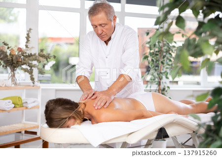 male masseur giving massage to female patient male masseur giving massage to female patient 137915260