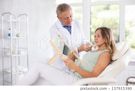 Elderly man doctor examining adult woman patient 137915390