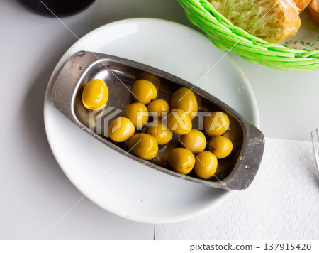 Marinated green olives with pits - typical Spanish tapas closeup Marinated green olives with pits - typical Spanish tapas closeup 137915420