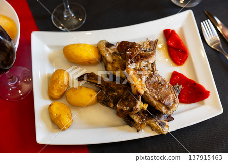 Fried lamb served with potatoes and peppers Fried lamb served with potatoes and peppers 137915463
