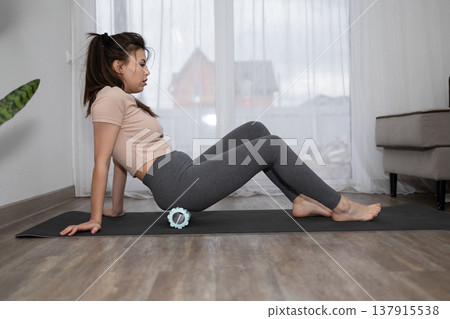 Woman Using Foam Roller on Glutes at Home During the Daytime Woman Using Foam Roller on Glutes at Home During the Daytime 137915538