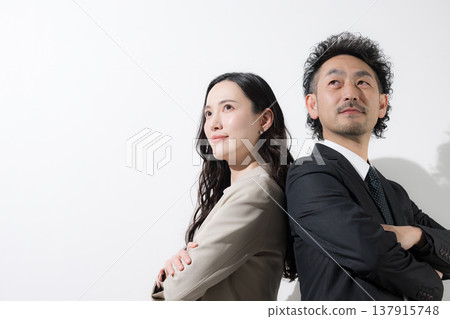 一男一女兩位商人背靠背站著,仰望著他們的目標和未來,背景是白色。 一男一女兩位商人背靠背站著,仰望著他們的目標和未來,背景是白色。 137915748