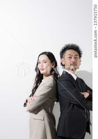 一男一女兩位商人背靠背站著，仰望著他們的目標和未來，背景是白色。 137915750