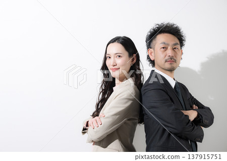 一男一女兩位商人背靠背站著，仰望著他們的目標和未來，背景是白色。 137915751