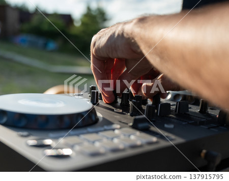 Close up of DJ's hands while working outdoors.  137915795