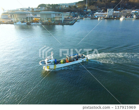 Aerial view of fishing boats entering and leaving Ochibe Fishing Port in Yakumo Town, Hokkaido, in early spring. Aerial view of fishing boats entering and leaving Ochibe Fishing Port in Yakumo Town, Hokkaido, in early spring. 137915969