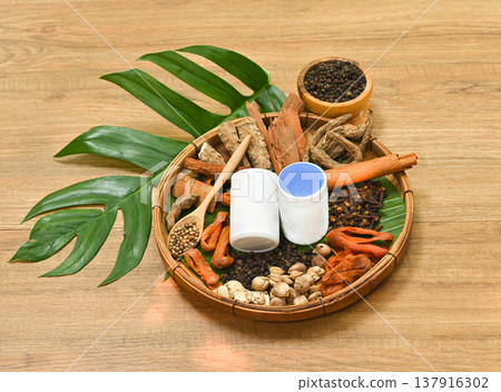 Thai herbal medicine ingredients menthol, camphor, borneol, clove and cinnamon in a wooden basket, aromatic natural herbs for inhaler and traditional wellness concept. 137916302