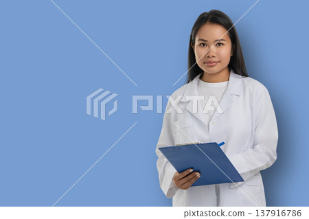 Medical worker in white coat stands holding clipboard Medical worker in white coat stands holding clipboard 137916786