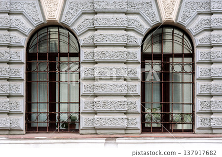 Two arched windows with grilles. Two arched windows with grilles. 137917682
