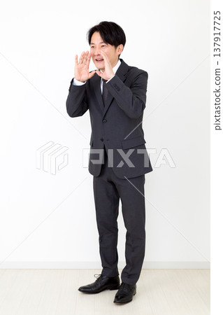 A middle-aged businessman in a suit cheering on his team. 137917725