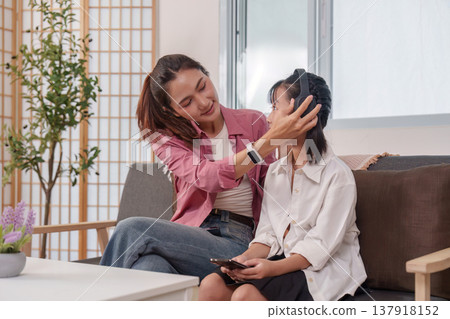 Mother helping daughter with headphones Mother helping daughter with headphones 137918152