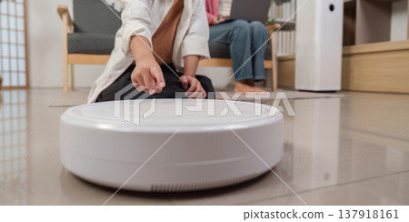 Close-up of a robotic vacuum cleaner in use at home Close-up of a robotic vacuum cleaner in use at home 137918161