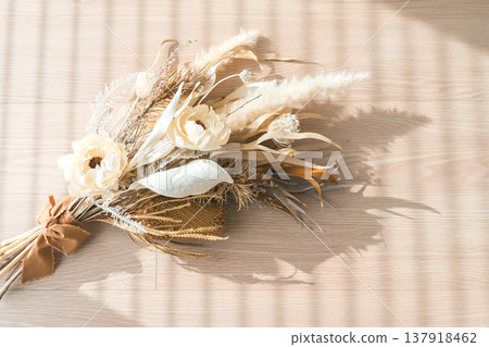 Bouquets, swags, and dried flowers on a sunny wooden floor. Bouquets, swags, and dried flowers on a sunny wooden floor. 137918462