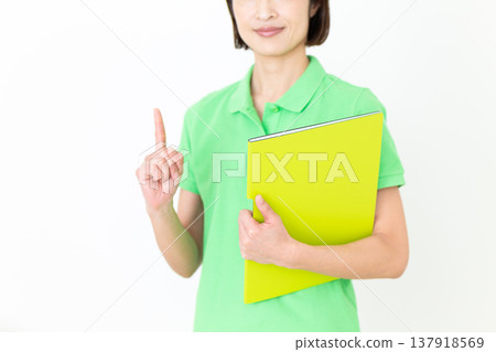 A middle-aged female care worker holding up her index finger. A middle-aged female care worker holding up her index finger. 137918569