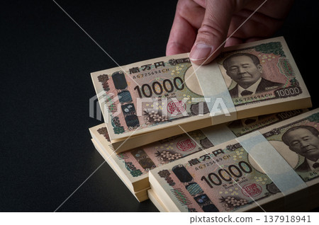 一疊鈔票。一幅陰暗的畫面。 137918941