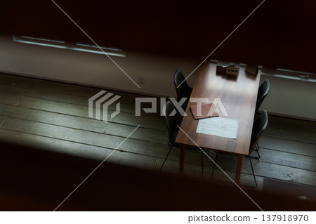 昏暗房間裡擺放著一張餐桌。 昏暗房間裡擺放著一張餐桌。 137918970