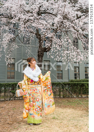 日本女性身著振袖和服，在櫻花樹下慶祝成年禮。 137919354