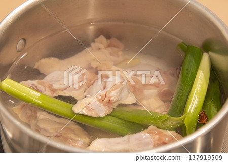 專業廚房裡的一幕：雞肉和蔥花在大鍋裡慢燉，熬煮雞湯。這是製作雞湯的過程。 137919509