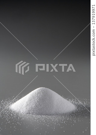 White salt mounds against a black background; minimalist food photography with dramatic lighting; seasonings and concept materials. White salt mounds against a black background; minimalist food photography with dramatic lighting; seasonings and concept materials. 137919971