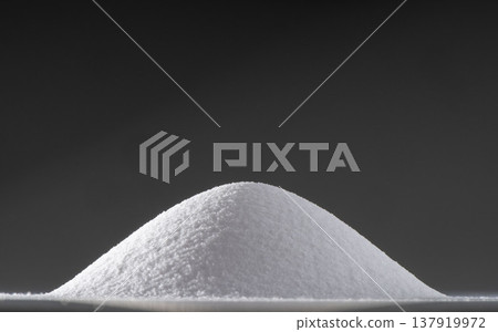 White salt mounds against a black background; minimalist food photography with dramatic lighting; seasonings and concept materials. 137919972