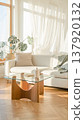 A bright, natural living room with a white sofa, monstera plant, glass table, and stylish Scandinavian-style interior. 137920132
