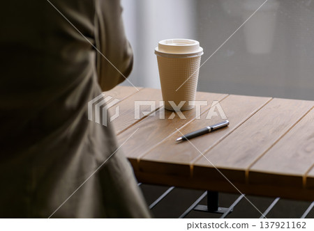 Coffee and a pen placed on a cafe table Coffee and a pen placed on a cafe table 137921162