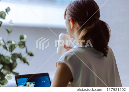 A woman drinking coffee by the window 137921202