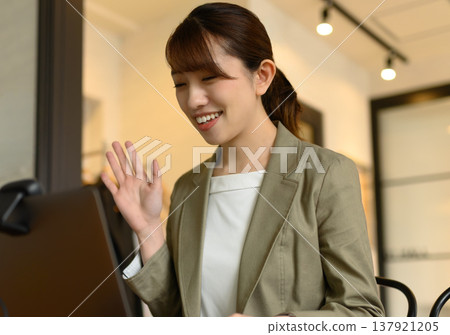 一位女士在網路會議中打招呼。 137921205