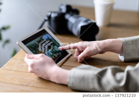A woman checking video editing on a tablet. 137921210