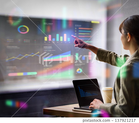 A businesswoman checks graphs on her PC by the window. 137921217