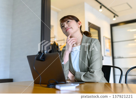 一個女人一邊看筆記本電腦一邊思考 137921221