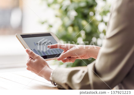 A woman checking data analysis on a tablet. 137921223