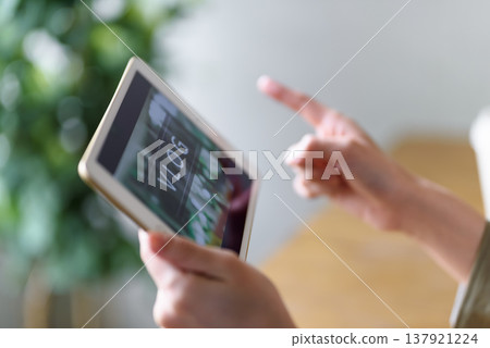 A woman watching a vlog on her tablet. 137921224