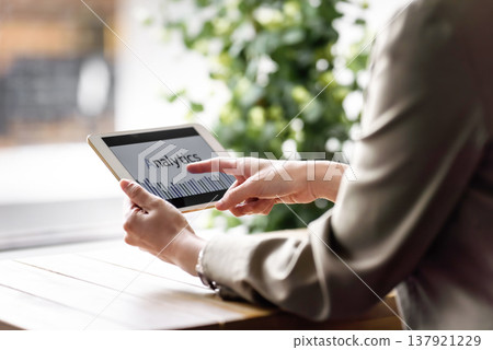 A woman checking data analysis on a tablet. 137921229