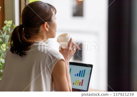 A woman looking out the window and a graph on a PC. 137921239