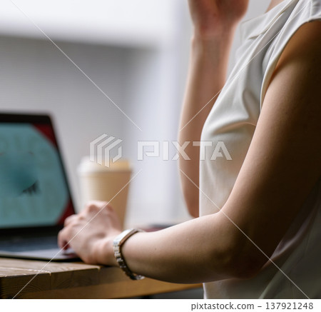 A woman is working on her laptop at a cafe. 137921248
