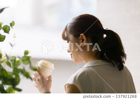 The woman quietly savors her drink. 137921268