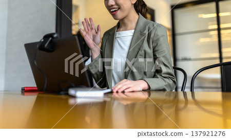 一位女士在網路會議中揮手 137921276