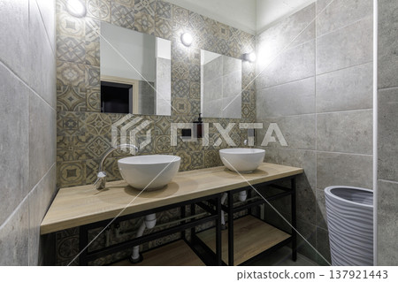 Modern Hostel Bathroom with Double Vessel Sinks and Patterned Tiles Modern Hostel Bathroom with Double Vessel Sinks and Patterned Tiles 137921443