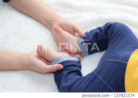 A hand holding the baby's feet 137921574