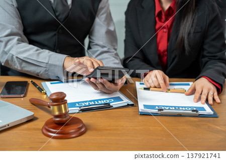 Business lawyer meeting working with paperwork on desk in office workplace for consultant lawyer in office. Business lawyer meeting working with paperwork on desk in office workplace for consultant lawyer in office. 137921741